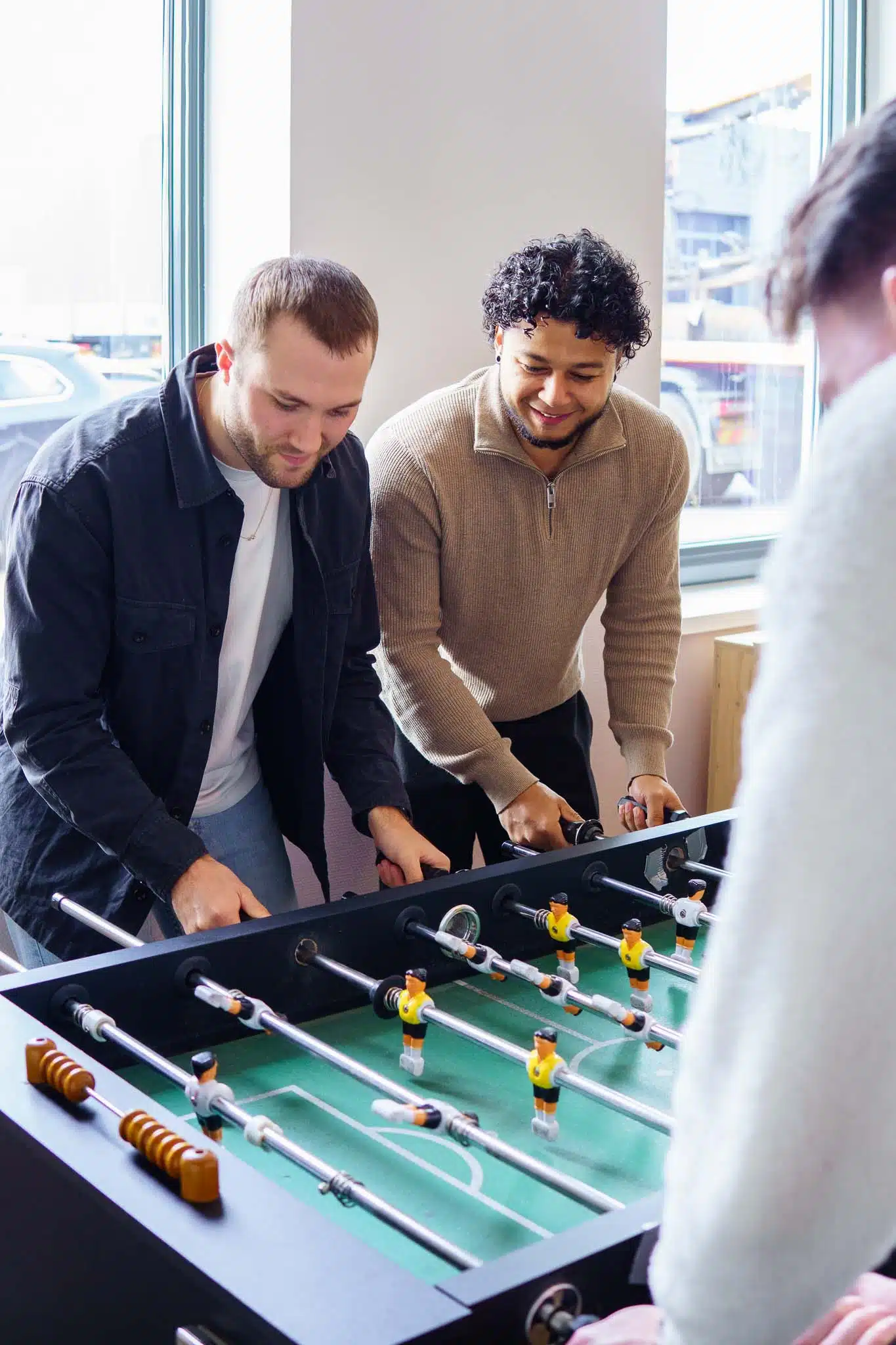 Collega's zijn aan het tafelvoetballen tijdens de lunchpauze